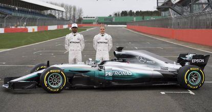 Los pilotos británico Lewis Hamilton (izquierda) y finlandés Valtteri Bottas, de la escudería Mercedes-AMG Petronas, posan junto al nuevo monoplaza W08, durante la presentación del coche de carreras en el circuito de Silverstone (Reino Unido).