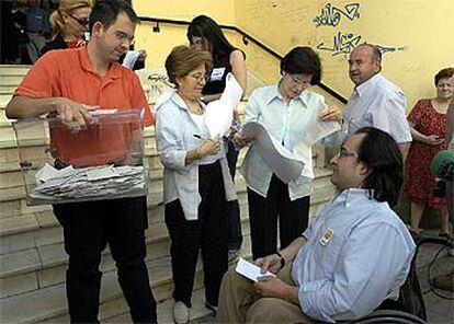 Los integrantes de una mesa de Jaén acercan la urna a un elector impedido para acceder al colegio.
