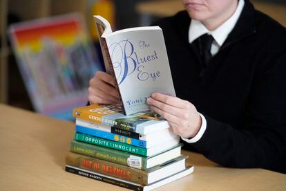 Una lectora sostiene 'Ojos azules', de Toni Morrison, sobre una pila de libros que suelen engordar la lista de los más prohibidos en Estados Unidos.