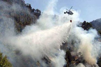 Un helicóptero lanza agua sobre el incendio de la sierra de Las Villas, en Jaén.