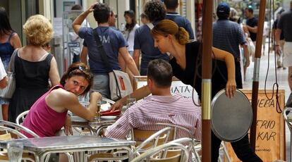Clientes en la terraza de una cafetería en la ciudad de Valencia.