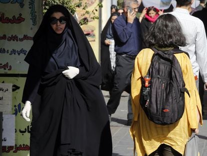 Una adolescente pasa sin velo junto a una mujer ataviada con el chador en Teherán, el 13 de septiembre.