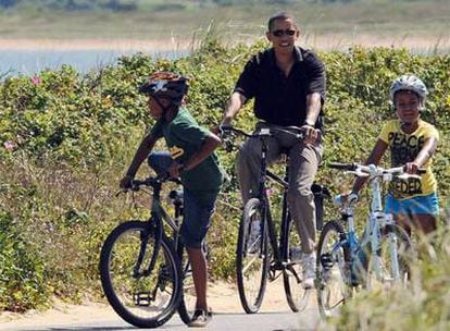 Obama pasea en bicicleta con sus hijas en Chilmark, en Massachussetts (EE UU), el pasado agosto.