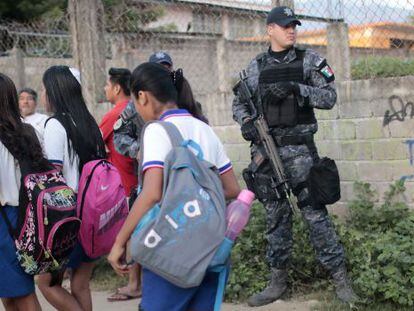 Un militar protege a unos alumnos en Acapulco.