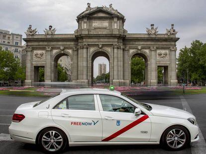 Un taxi con la nueva marca FreeNow pasa por la Puerta de Alcalá, en Madrid.