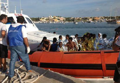 Unos inmigrantes consiguen ser rescatados tras el incendio de una patera a media milla de la isla de los Conejos, en Lampedusa, 3 de octubre de 2013. El rescate, en el que participan barcos pesqueros y patrulleras de las guardias Costera y de Finanzas, ha logrado rescatar con vida a 150 inmigrantes.