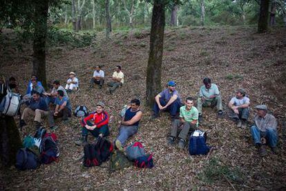 Los miembros de la cuadrilla que trabajan en la saca del corcho en la finca Los Gavilanes del parque natural Los Alcornocales esperan reunidos a que sea la hora de comer.