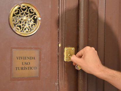 Un viajero abre la puerta de una vivienda de uso tur&iacute;stico en Madrid.