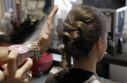 Una peluquera peina a una clienta en una peluquería. EFE/Archivo