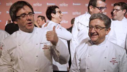 El presidente de la Generalitat, Carles Puigdemont, y el delegado del Gobierno en Cataluña, Enric Millo durante la presentación de La Guía Michelin España&Portugal.