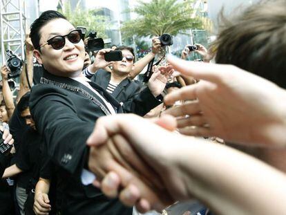 El cantante surcoreano Psy saluda a sus seguidores en Bangkok.