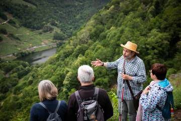 Francisco Almuíña explica el paisaje de la Ribeira Sacra, por el Camiño da Virxe, a un grupo de personas.