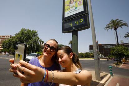 Dos turistas se fotografiaban el domingo junto a un termómetro que marcaba 44 grados en Córdoba. 
