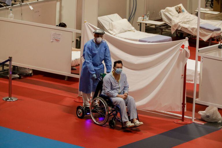 Un sanitario traslada a un paciente en el hospital de campaña de Ifema, en Madrid, este lunes.