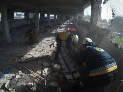 Dos 'cascos blancos' recuperan el cuerpo de Yahya al Judur, de 20 años, tras el bombardeo contra una granja de Maarrat Misrin, en Siria, el día 11. Imagen cedida por Syria Civil Defense.