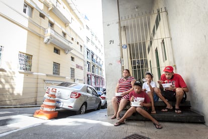 Maxwell Oliveira y Verônica Medeiros almuerzan, junto con sus dos hijos, tras recibir una donación de alimentos de una ONG, en São Paulo.