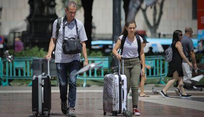 Turistas con maletas por el centro de Barcelona.