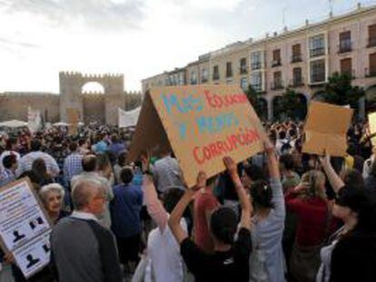Varios jóvenes muestran una pancarta durante la manifestación del Movimiento 15-M convocada esta tarde en Ávila.