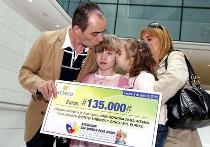 Aitana muestra, con sus padres y hermana, el cheque de 135.000 euros ganados con el reciclaje de tapones.  