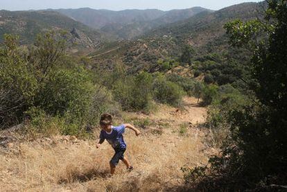 Un niño corre por uno de los senderos que transitaron los maquis, en Santa María de Trassierra (Córdoba) .