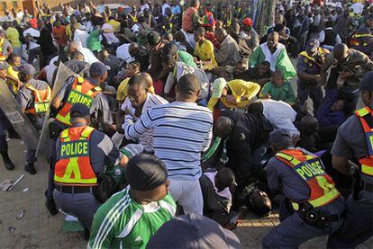 La policía intenta contener a los miles de aficionados que intentaban entrar por la fuerza al estadio