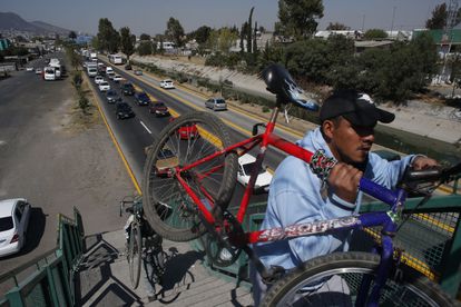 Hombres cargan sus bicicletas por un puente peatonal en Ecatepec, municipio conurbado de Ciudad de México, en 2016.