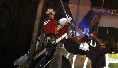 Los bomberos mueven el cuerpo de un hombre que fue arrastrado por la corriente.