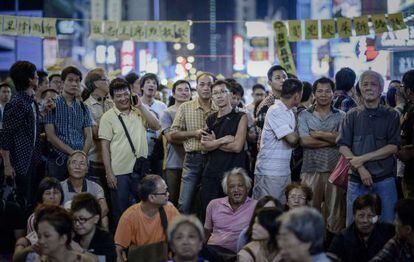 Un grupo de personas escucha un discurso improvisado por organizadores del movimiento prodemocracia en Hong Kong, este lunes.