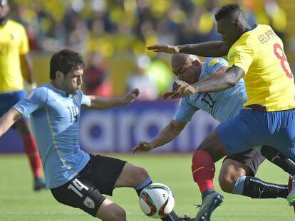 Lodeiro y Arévalo, de Uruguay, intentan frenar a Caicedo.