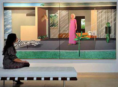 Una empleada de la casa de subastas Christie's contempla la obra titulada 'Beverly Hills Housewife', realizada por el artista David Hockney