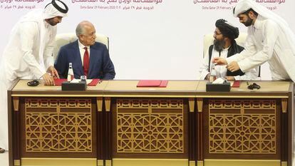 El embajador estadounidense Zalmay Khalilzad (izquierda) y el jefe negociador talibán, Abdulghani Baradar, en la firma del acuerdo para la retirada de las tropas norteamericanas de Afganistán, en Qatar el pasado febrero.