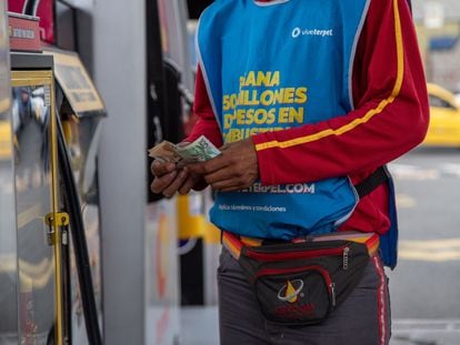 Un hombre cuenta billetes de pesos colombianos, en una estación de servicio en Cali, el 8 de junio de 2023.