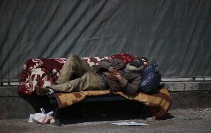 Un banco de una calle de Lisboa sirve de cama a un mendigo. 14 de mayo de 2014.