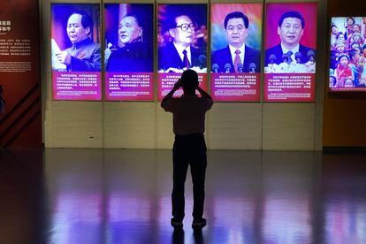 Un visitante fotografía en un museo de Pekín los retratos de Xi Jinping y sus predecesores al frente de China, el 27 de septiembre.