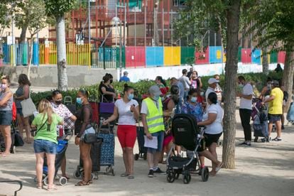 Vecinos durante un reparto de alimentos en el barrio de Aluche de Madrid, el verano pasado.