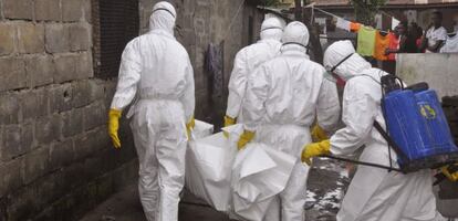 Personal sanitario traslada el cadáver de una víctima del ébola en Monrovia.