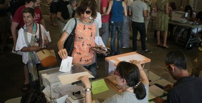 Una mujer vota en una urna en un colegio electoral de Barcelona.