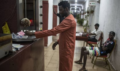 Un cliente paga en el puesto de comida rápida de Amar Diop, en Saint Louis.