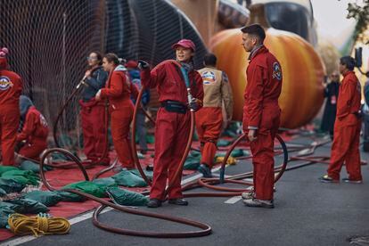 Los globos son inflados con helio que viaja a través de las mangueras rojas que llevan los trabajadores.