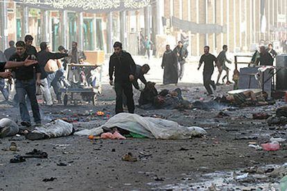 Civiles iraquíes retiran heridos y cadáveres de la zona donde ocurrió una de las explosiones de ayer en la ciudad de Kerbala.