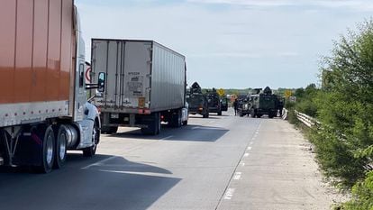 Vehículos de las fuerzas armadas bloquean la carretera en el lugar de los hechos.