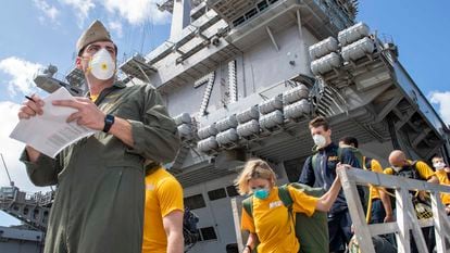 This handout photo released by the US Navy shows sailors assigned to the aircraft carrier USS Theodore Roosevelt (CVN 71) wearing face masks as they depart the ship to move to off-ship berthing, April 10, 2020. - A sailor who was aboard the USS Theodore Roosevelt aircraft carrier died on April 13, 2020 of COVID-19, the first fatality from nearly 600 confirmed cases among its crew, the US Navy said. (Photo by Chris LIAGHAT / US NAVY / AFP) / RESTRICTED TO EDITORIAL USE - MANDATORY CREDIT "AFP PHOTO / US NAVY / MC1 CHRIS LIAGHAT " - NO MARKETING - NO ADVERTISING CAMPAIGNS - DISTRIBUTED AS A SERVICE TO CLIENTS