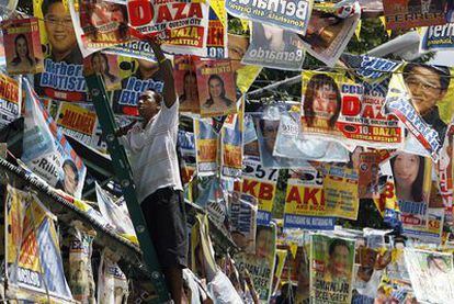 Un trabajador descuelga los carteles electorales en Ciudad Quezón tras los comicios en Filipinas.