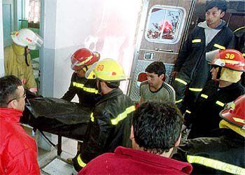 Los bomberos retiran el cadáver de un estudiante asesinado en la escuela de Carmen de Patagones.