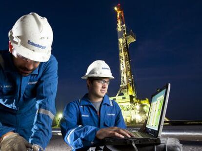 Trabajadores de Schlumberger junto a una plataforma petrol&iacute;fera. 