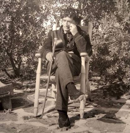 Salvador Dalí fotografiat per Vehí assegut a la cadira de sis potes que el fotògraf-fuster havia fet.