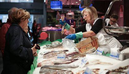 Una dona compra peix al mercat de Sants.