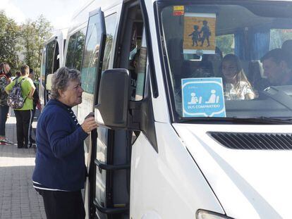 Una mujer compra el billete en un bus de transporte escolar de un municipio de Ourense.