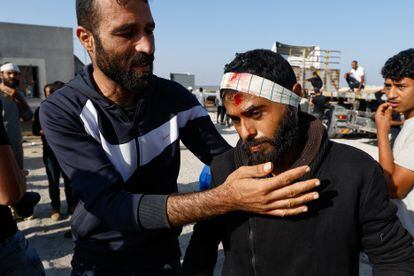 El trabajador palestino Khaled al-Bahnasi (a la derecha), que se encontraba en Israel tras el ataque de Hamás, es recibido en el paso fronterizo de Rafah. Al-Bahnasi declaró que fue golpeado en la cabeza por las fuerzas israelíes. 