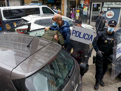 Agentes de Policía introducen en el coche a uno de los detenidos este sábado en una vivienda de la calle Francisco Grandmontagne de Burgos.